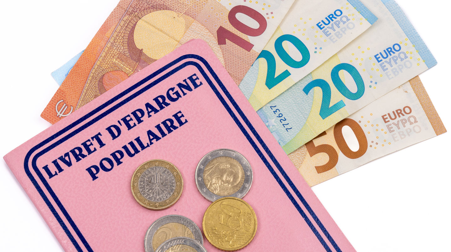 Des mains tiennent un relevé bancaire papier au-dessus d'une table en bois clair avec une calculatrice et un stylo Des mains tiennent un relevé bancaire papier au-dessus d'une table en bois clair avec une calculatrice et un stylo